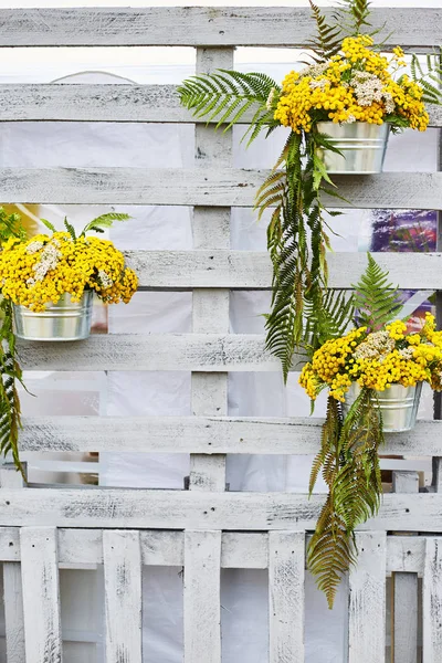 Fleurs de mimosa jaune avec des pots en métal sur fond en bois . — Photo