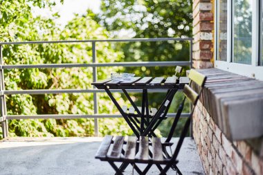 Rahatlamak için bir yer. Bir kır evinin terası. Sandalyeli masa.