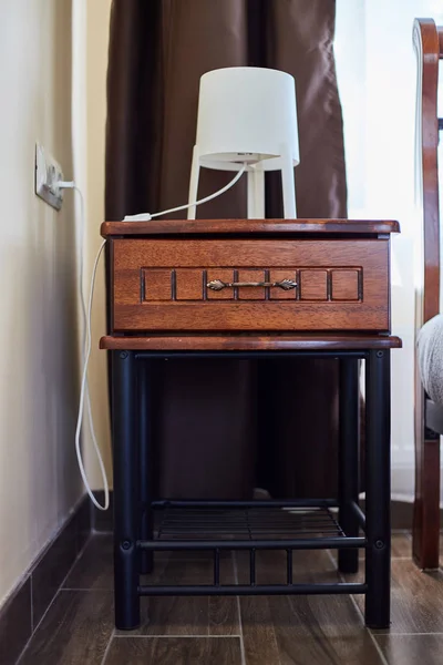 A bedside table made of wood with a lamp. Hotel Interior — Stock Photo, Image