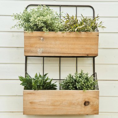 Dekoratif tahta kutular, beyaz bir duvarda çiçekler..