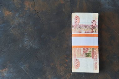 Rus rublesi. Karanlık bir arka planda beş bin dolarlık banknot yığını. Mesaj için yer. Boşluğu kopyala