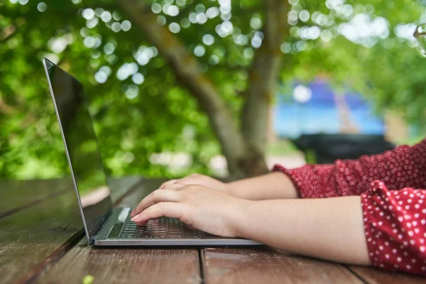 An open laptop stands on a wooden table. High-quality photo