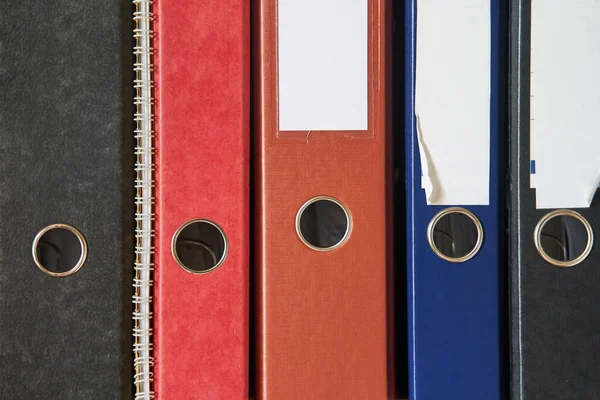 Colored folders for office files and paper on a shelf. Background image — Stock Photo, Image