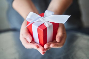 Elinde küçük kırmızı bir kutu tutan bir kadın..