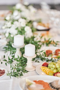 Bir düğün kutlamasında şamdanların içinde beyaz mumlar