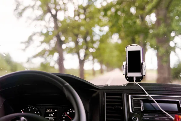 Мобильный телефон с GPS-картой в машине. Для навигации используется белый смартфон на стойке в машине. — стоковое фото
