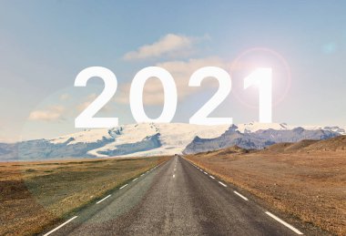 2021 kelimesi bir buzulun ve boş bir asfalt yolun arkasında altın bir günbatımına ve güzel mavi gökyüzüne karşı yazılmıştır.. 