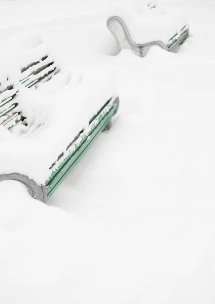 stairs and bench covered with snow. the drifts and snow piles