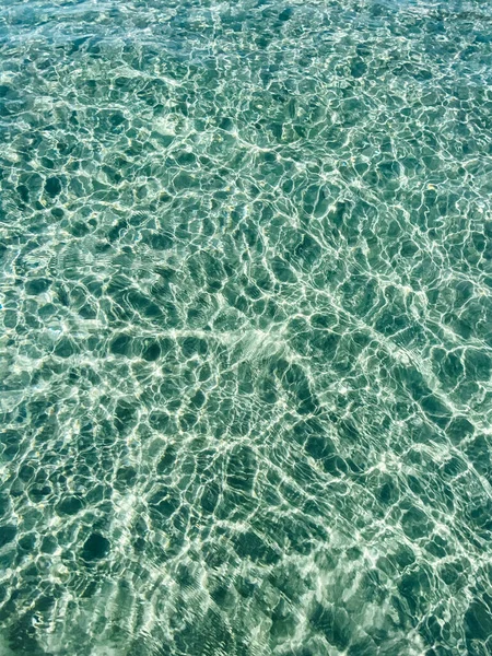 在透明清澈的海面上的小浪花 阳光灿烂的天气里 水面上闪烁着阳光 海洋情节 背景平静的海浪 复制空间 — 图库照片