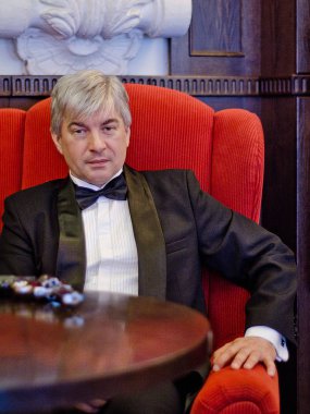 Gri saçlı yaşlı gangster bir iç. Gri saçlı yaşlı gangster bir silah daşu eski evinin siyah elbiseli.