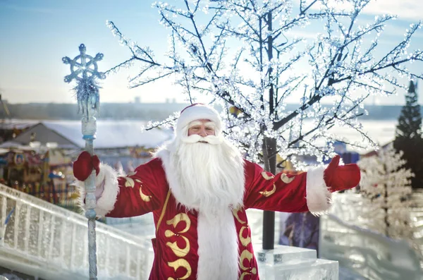 Buz şehir fuarlarından bir arka plan üzerine açık havada neşeli Noel Baba olduğunu