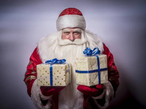 有趣和有趣的圣诞老人在灰色的背景祝贺 并给了很多礼物 — 图库照片