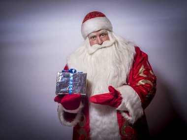 Gri bir arka plan üzerinde eğlenceli ve komik Noel Baba tebrik ve verir bir