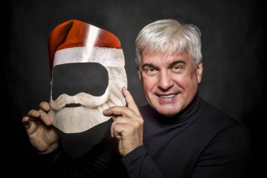 Noel Baba gibi giyinmiş ve karanlık bir arka plan üzerinde duran yaşlı bir zengin adam