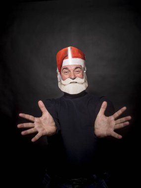 Noel Baba gibi giyinmiş ve karanlık bir arka plan üzerinde duran yaşlı bir zengin adam