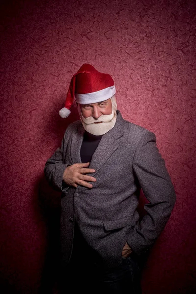 Пожилой Богатый Человек Костюме Санта Клауса Стоит Красном Фоне — стоковое фото
