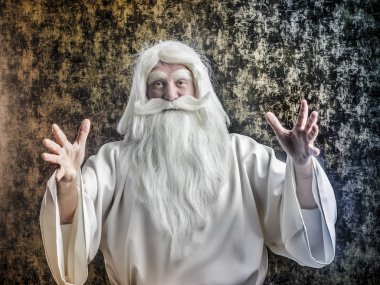 Bir gri saçlı sakallı şiddetli Sihirbazı'nda beyaz bir pelerin sihirli büyülü bir karanlık-altın arka plan yapıyor.