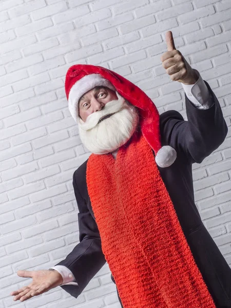 Ein grauhaariger bärtiger Mann im schwarzen Anzug und im Bild des Weihnachtsmannes. — Stockfoto