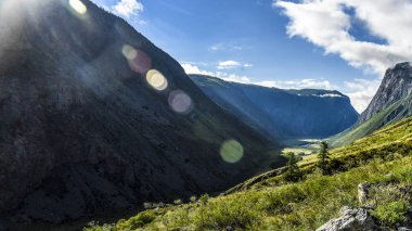 Güzel manzarası ve altay doğa manzara. Yüksek dağlar ve kayalıklarla mavi gökyüzü bulutlu güneşli bir karşı görkemli manzara.
