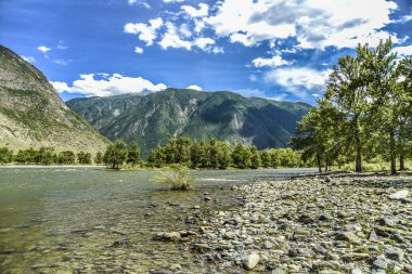 Güzel manzarası ve altay doğa manzara. Dağ nehir taş ve çakıl dağlar ve mavi gökyüzü bulutlu güneşli bir zemine karşı.