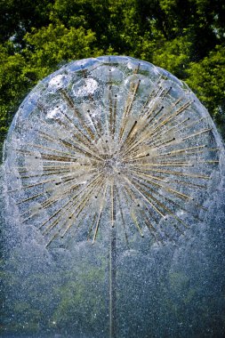 Güzel ve özgün çevre pınarlarına. Güzel Çeşme jetleri ritmine ve arka ışık güneş ile yaz öğleden sonra bir top şeklinde bir çeşme ile.