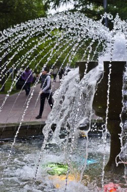 Zemin şehrin karşı yaz öğleden sonra su ve kenarlık toplamak için güzel bir çeşme jets ve bir yüzme havuzu ve bir tank ritim ile.