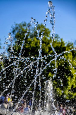 Güzel ve özgün çevre pınarlarına. Güzel bir çeşme ile ilginç bir yaz öğleden sonra arkadan aydınlatmalı güneş ile kentsel bir ortamda jetleri ritmine.