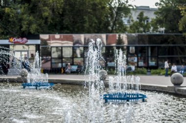 Zemin şehrin karşı yaz öğleden sonra su ve kenarlık toplamak için güzel bir çeşme jets ve bir yüzme havuzu ve bir tank ritim ile.