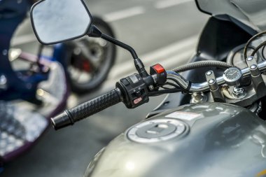 Şehrin arka plan üzerinde motosiklet. Güzel ve şık kontrol paneli ve modern bir motosikletin arka planı kentin yakın mesafeden direksiyon simidi.