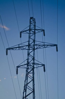 Elektrik direkleri gökyüzüne karşı. Yüksek voltajlı elektrik hatları mavi gökyüzü bulutlu karşı güçlü ve güçlü kutup.