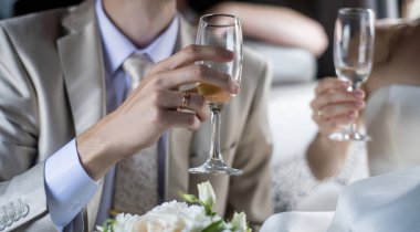 Düğün tema ve stil. Gelin ve damat eller güzel ve şık buket beyaz gül ve bardak şampanya ile birlikte düzenlenmektedir.