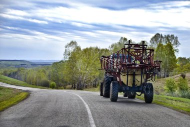 Doğanın güzel manzara. Güzel ve ilginç manzara, panorama, arka plan ve bir yol ve bir traktör yaz öğleden sonra ile kırsal görünümü.