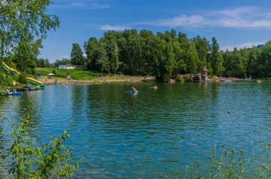 Güzel ve ilginç manzara ve yaz nehir veya göl ile yeşil çalılar ve mavi gökyüzü ile çim.