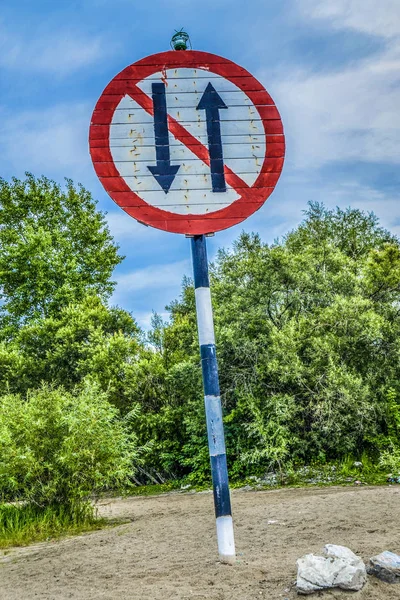 Road sign on the road. Funny road sign on the countryside dorga with blue sky and forest.