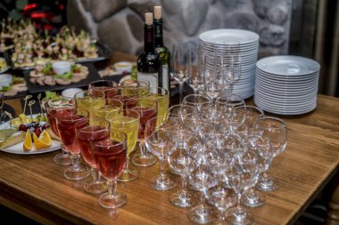 Bir güzel tablo ayarı ile çeşitli bir ve büyük snack, sandviç ve kanepeler bir tepsi ve bir kafe, bar ve Restoran İç karanlık bir arka plan üzerinde gözlüklü.