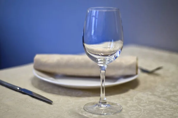 Beautiful dishes in the interior. Beautiful table setting with glasses, plates and napkins on a light background and in the interior of the cafe, bar and restaurant.