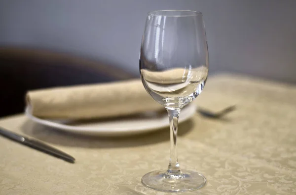 Beautiful dishes in the interior. Beautiful table setting with glasses, plates and napkins on a light background and in the interior of the cafe, bar and restaurant.