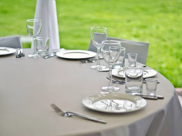 Beautiful dishes in the interior. Beautiful table setting with glasses, plates and napkins on a light background and in the interior of the cafe, bar and restaurant.