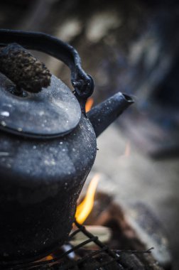 Güzel ve farklı bir konu. Bir yaz öğleden sonra doğada yangında ateşe kurum içinde eski ve harap siyah çaydanlık.