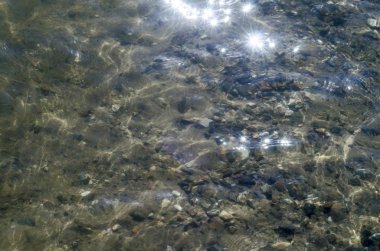 Güzel doku doğa. Güzel arka plan ve şeffaf su ile bir alt kum ve taşların gündüz deniz, nehir ve göl pürüzsüz yüzey dokusu görünümünü.