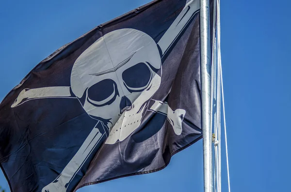 Beautiful pirate flag. Beautiful background and view of the pirate and robber black with bones and skull flag and standard day in summer.