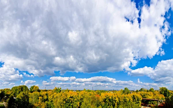 Beautiful and original panorama. Beautiful background and view, landscape and panorama of the city and industry, the park against the blue sky with clouds in the fall.