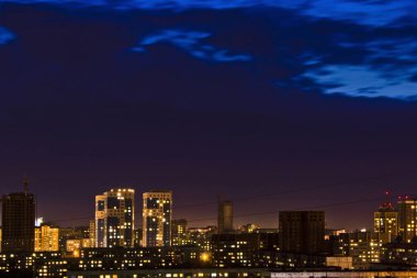 Güzel arka plan ve görünümü, manzara ve gece veya akşam şehir panoraması, binaları ve sokakları yukarıdan aydınlatmaları ile çatılar.