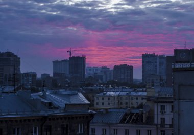Güzel arka plan ve görünümü, manzara ve günbatımı veya gündoğumu, gece veya akşam şehir panoraması, binaları ve sokakları yukarıdan aydınlatmaları ile çatılar.