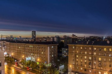 Güzel arka plan ve görünümü, manzara ve gece veya akşam şehir panoraması, binaları ve sokakları yukarıdan aydınlatmaları ile çatılar.