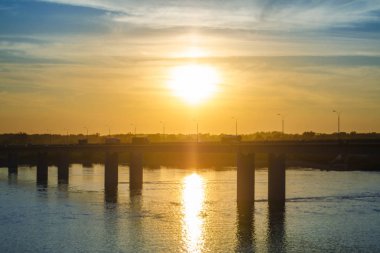 Güzel kentsel nesneler. Güzel arka plan, görünümü, manzara, gün batımı veya gündoğumu, akşam ya da sabah alacakaranlıkta turuncu bir güneş ile araba ile modern bir köprü Panoraması.