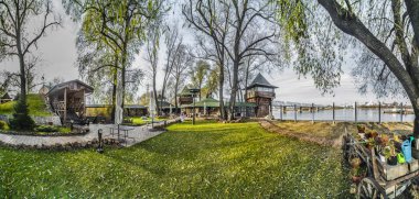 Novosibirsk, Rusya - 15 Ekim 2017. Güzel arka plan, görünümü, panorama, ahşap binalar, Bahçe, park yaz veya sonbahar günü ile nehir kenarında park eğlence bölgesinin peyzaj.