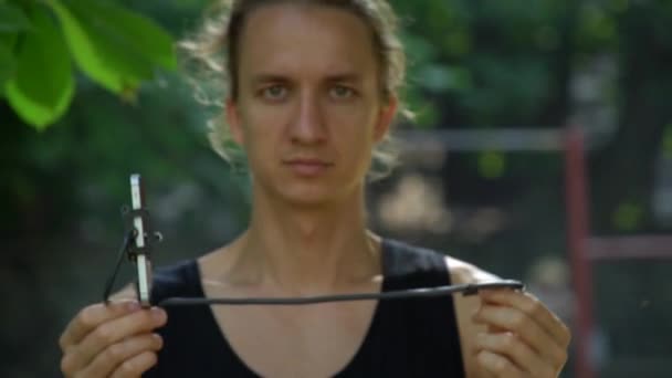 Junger Mann Mit Langen Haaren Präsentiert Handyhalter Selfie Stick Für — Stockvideo