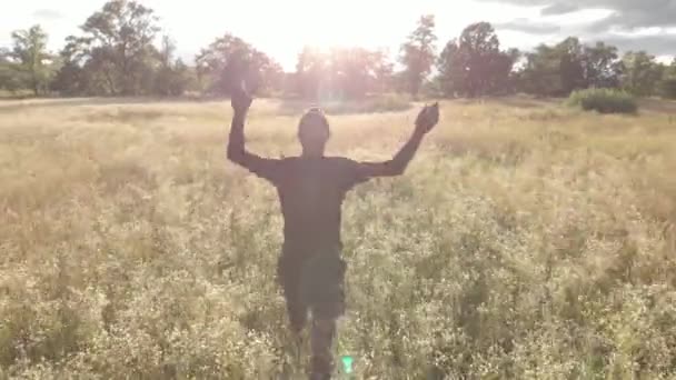 Junger Glücklicher Inspirierter Mann Schwarzen Läufen Motiviert Inmitten Eines Blumenfeldes — Stockvideo
