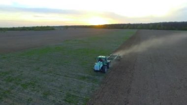 Yeşil traktör alanında çalışan hava dron görüntüleri, çiftçilik günbatımında Filed under